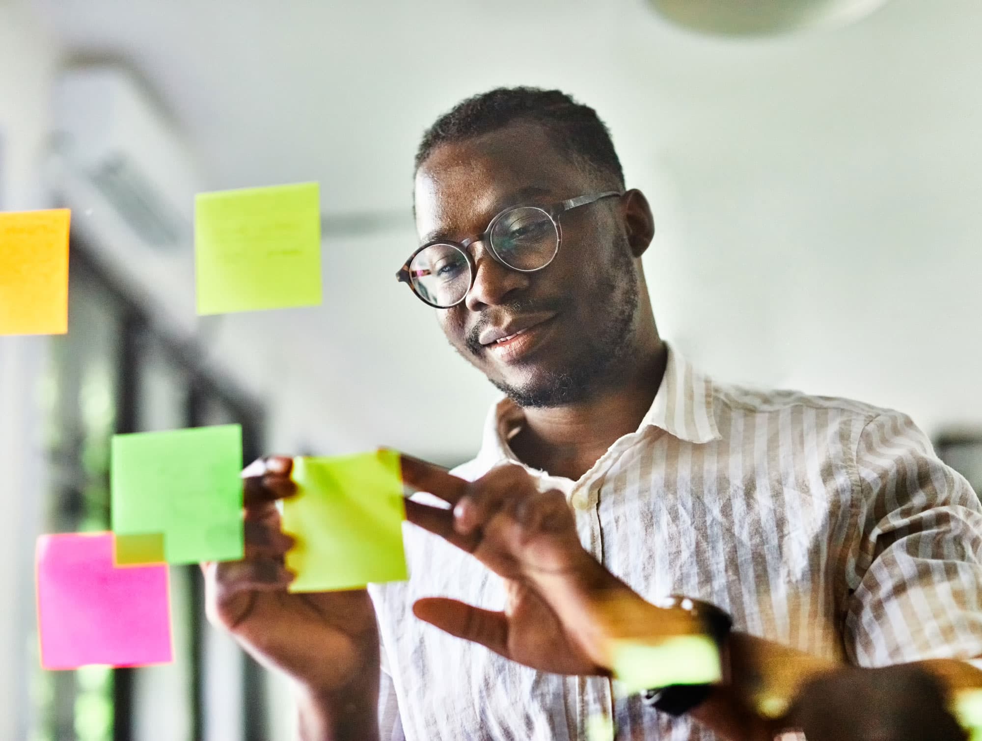 Consultant arranging sticky notes during a planning workshop